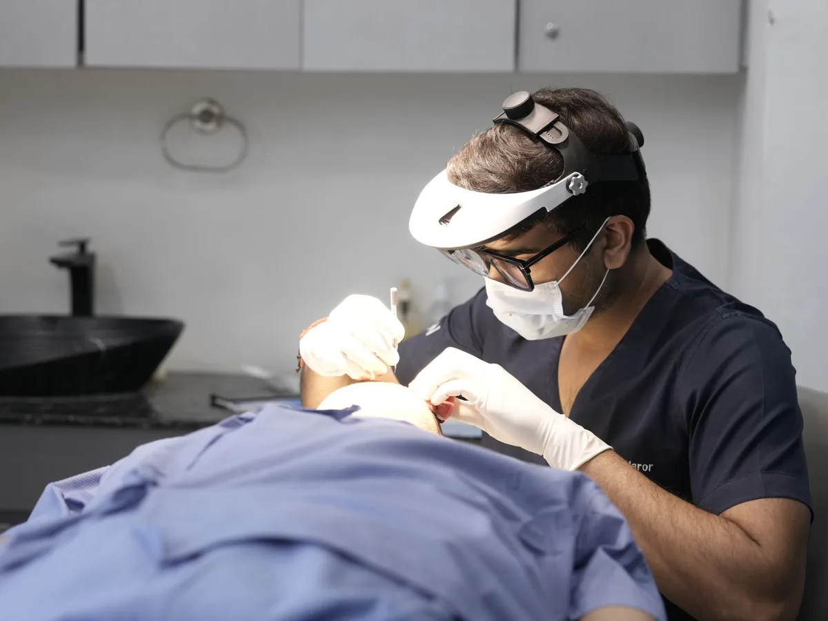Dermatologist wearing magnifying loupes performing a skin procedure on a patient