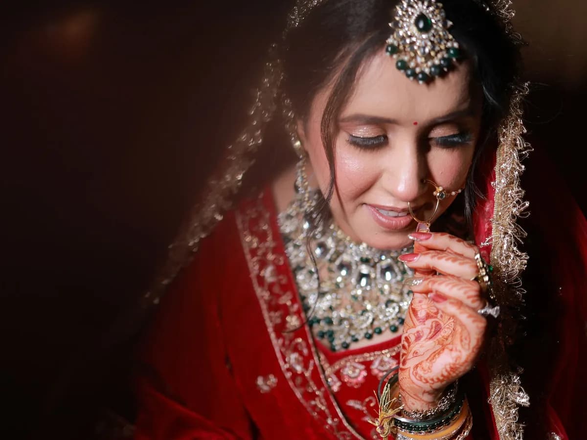 Indian bride in red bridal wear with glowing skin, photographed in soft light