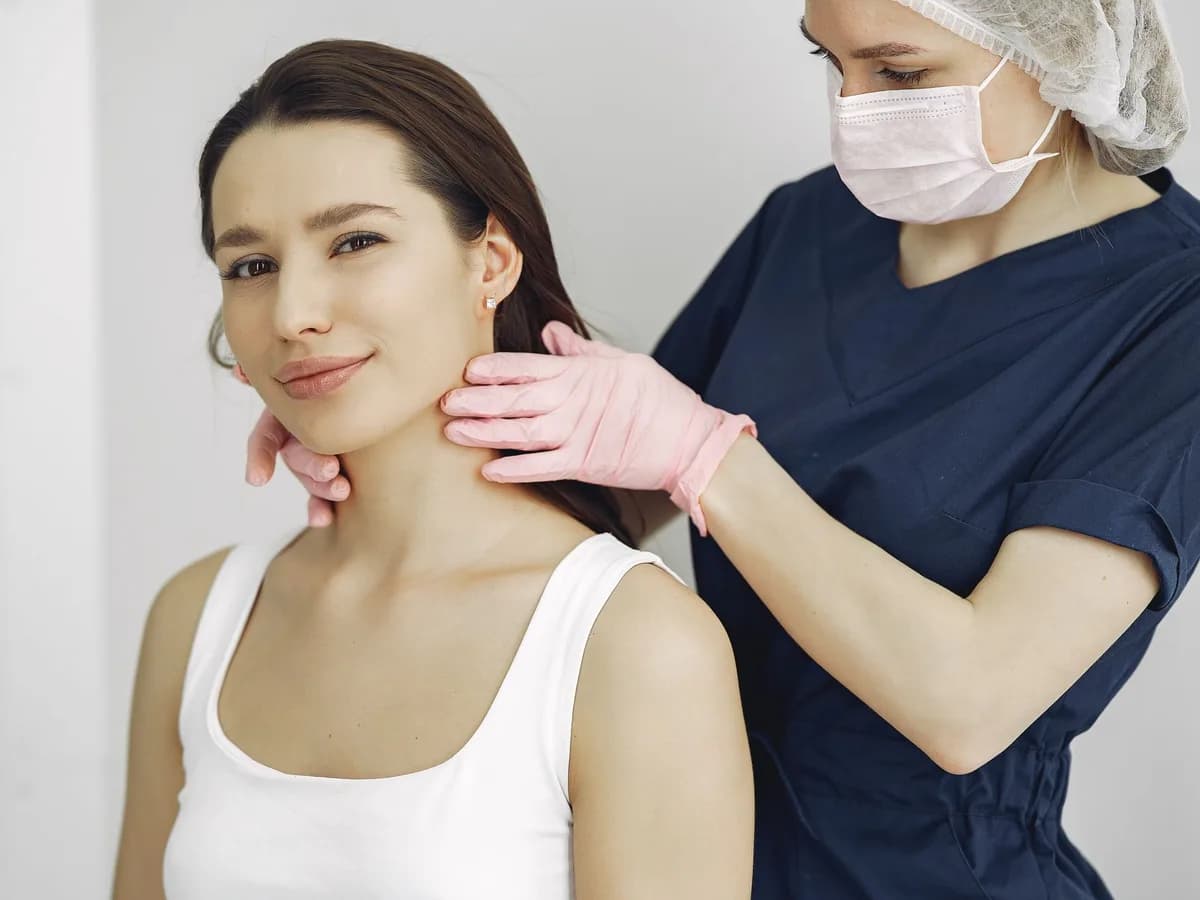 Dermatologist examining the skin on a smiling patient's neck