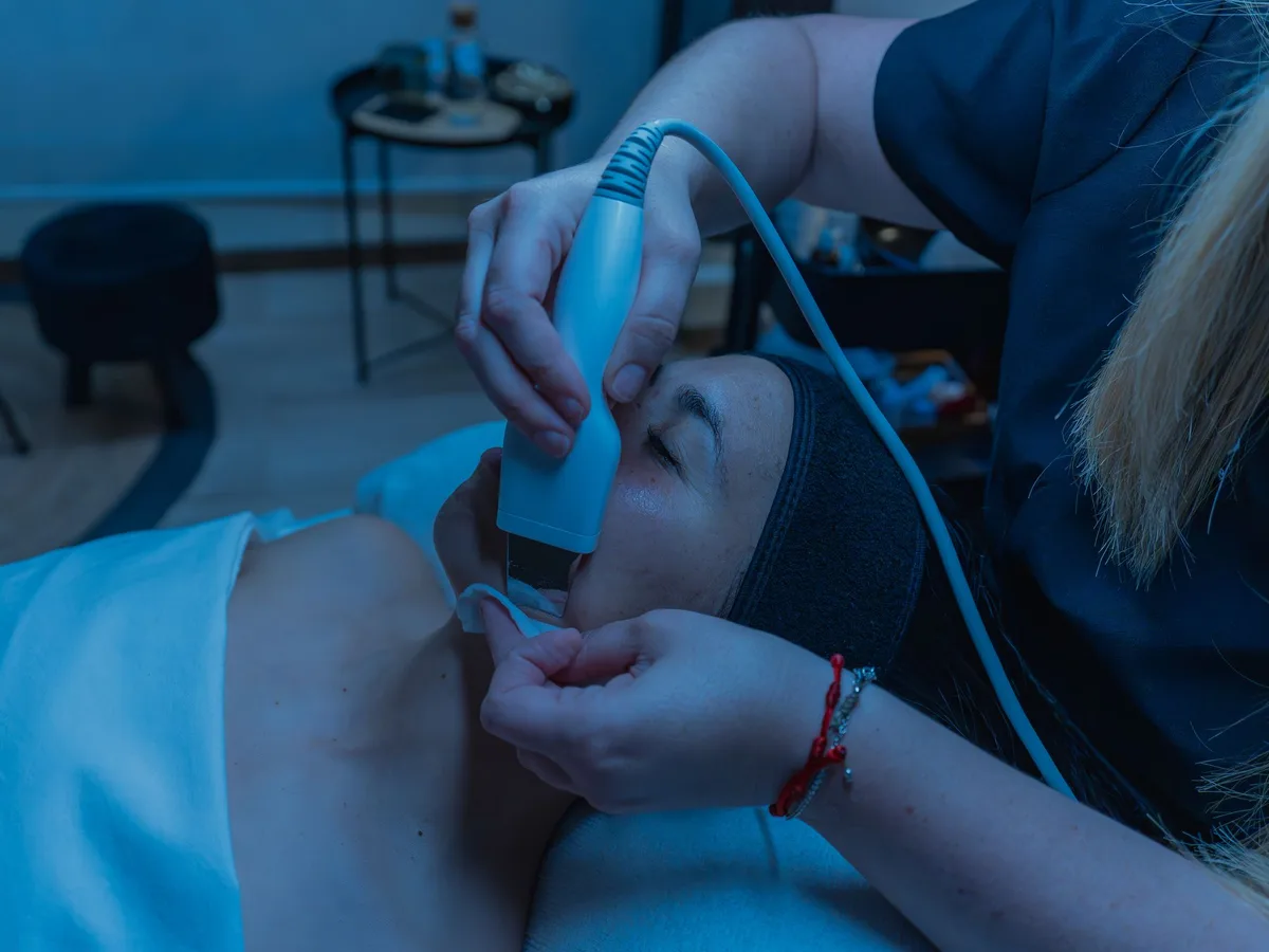 Handheld facial device being used on a patient's face in a clinic