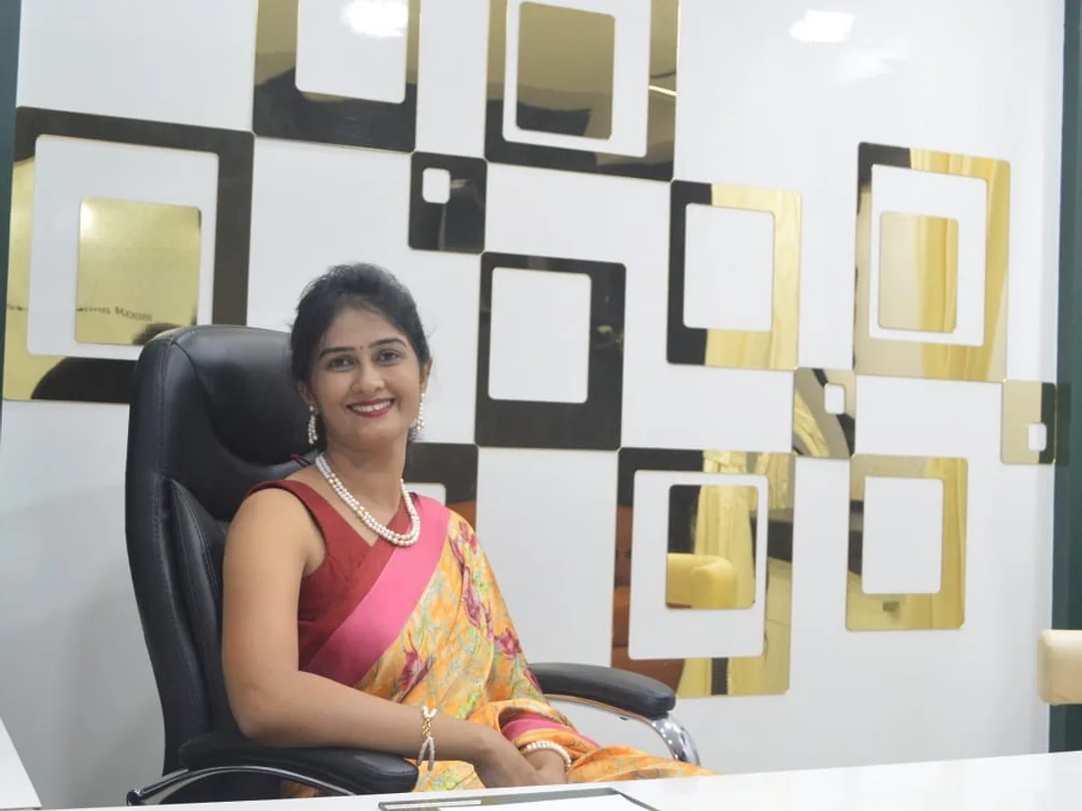 Dr. Daksha Patel, MBBS, MD (Skin & VD), smiling at her consultation desk